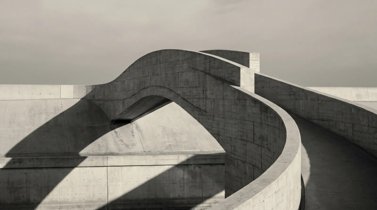 Pont del Mar: A modern curved pedestrian bridge with clean architectural lines and minimalist concrete structure