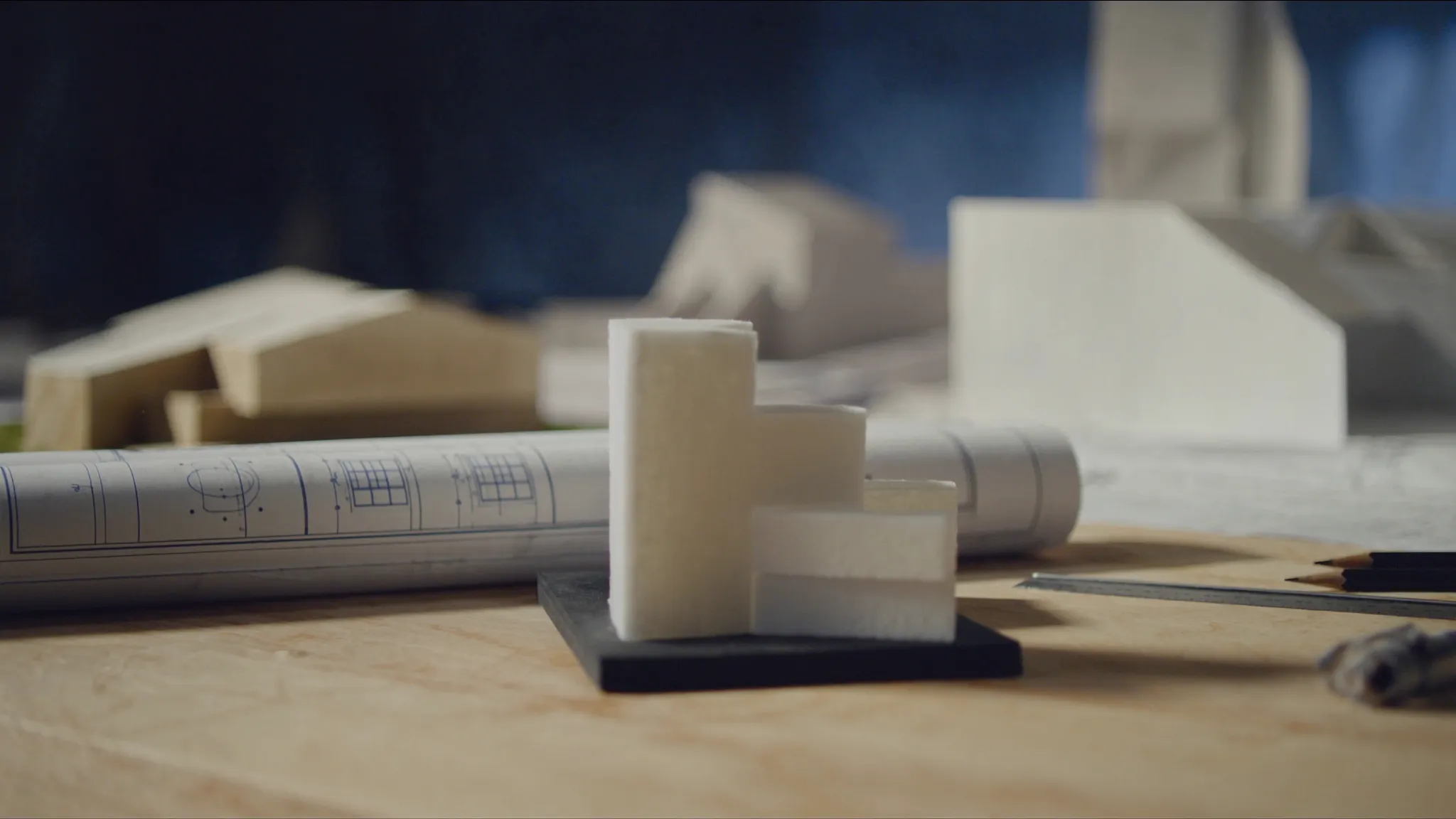 Architecture studio desk with white scale models and blueprints